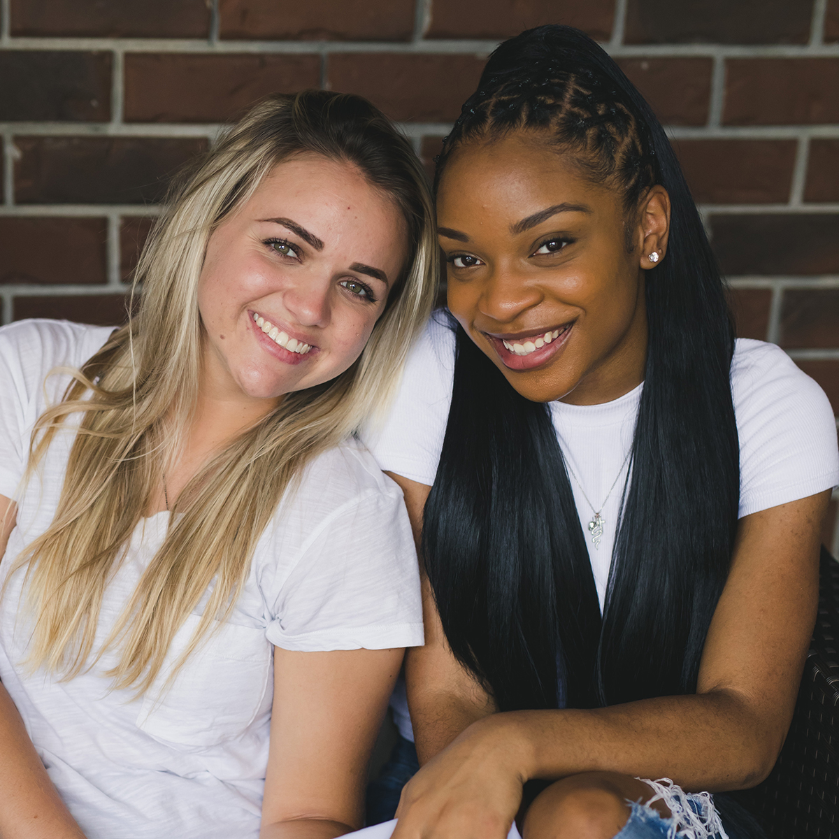 Two students smile at the camera